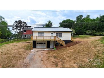 Charming home featuring a metal roof, deck, garage, and inviting curb appeal on a partially landscaped lot at 462 Berry Hill Dr, Norwood, NC 28128