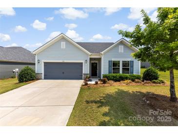 Charming single-story home with a well-manicured lawn, a gray garage door, and light blue siding at 5727 Lavaux Ct, Charlotte, NC 28214