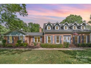 Charming brick home featuring dormer windows and well-maintained landscaping for inviting curb appeal at 6040 Morris Farm Ln, Mint Hill, NC 28227