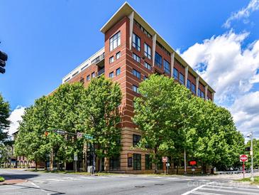 Brick condo building featuring expansive windows and lush trees on a bright day at 715 N Church St # 213, Charlotte, NC 28202