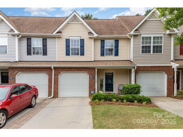 Charming townhouse with tan siding, blue shutters, and a one-car garage in a well-maintained neighborhood at 10617 Fuller Ridge Cir, Charlotte, NC 28270