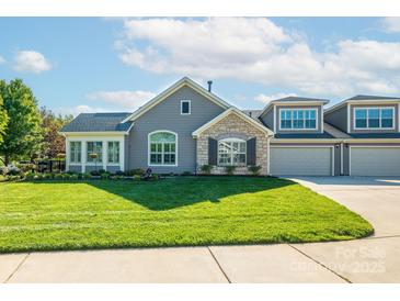 Charming home with stone accents, lush lawn, and a two-car garage on a sunny day at 1328 Somersby Cir, Gastonia, NC 28054