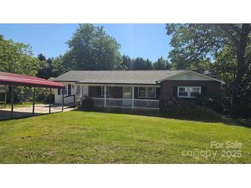 Charming brick home with a covered porch and carport, nestled on a lush lawn at 133 Pine State Rd, Troutman, NC 28166