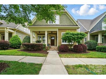Charming home featuring a quaint front porch, colorful landscaping, and a neatly maintained lawn at 15714 Laurel Oak Cres, Davidson, NC 28036