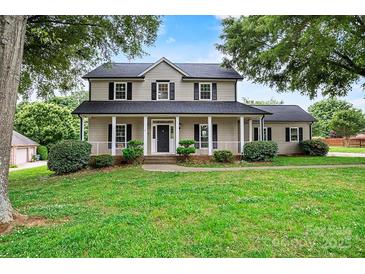 Charming two-story home with a welcoming front porch and well-manicured lawn and trimmed bushes at 188 Turnberry Ln, Mooresville, NC 28117