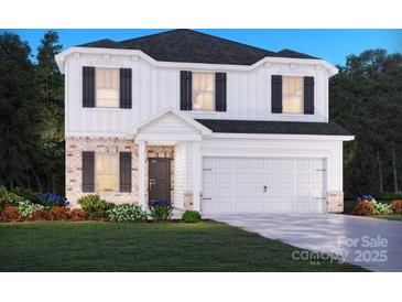 New two-story home with brick accents, a two-car garage, and professionally landscaped front yard at 2206 Silverbell Ln, Stanley, NC 28164