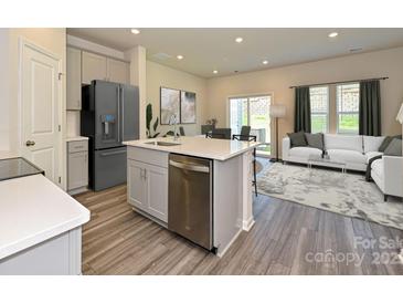 Modern kitchen featuring gray cabinets, stainless steel appliances, and an island with a sink at 4221 Summit Woods Dr, Charlotte, NC 28216