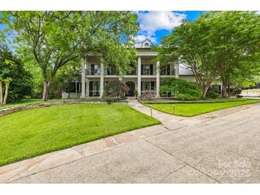 Stately home with a large front yard, mature trees, and a circular driveway at 4523 Fox Brook Ln, Charlotte, NC 28211