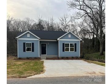 Charming one-story home featuring blue siding, black shutters, a black front door, and a concrete driveway at 601 Queens Rd, Gastonia, NC 28052