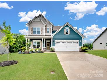Beautiful two-story home with a well-manicured lawn, two-car garage, and a welcoming covered front porch at 6381 Trinity Crossing Cir, Kannapolis, NC 28081