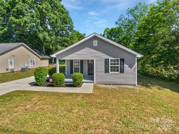 Charming home featuring a well-manicured front yard, gray siding, and black shutters at 905 Brookdale St, Kannapolis, NC 28083