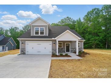 Charming two-story home featuring a gray exterior, stone accents, and a spacious two-car garage at 908 Westminster Dr, Statesville, NC 28677