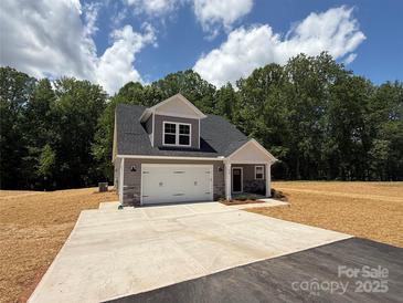 Charming new construction home featuring stone accents, a two-car garage, and a welcoming front porch at 908 Westminster Dr, Statesville, NC 28677
