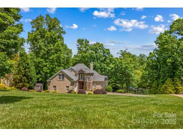 Stately brick home with a meticulously manicured lawn and mature trees offering shade and privacy at 141 Ridge Top Rd, Mooresville, NC 28117