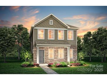 Charming two-story home with stone accents, manicured lawn, and beautifully landscaped garden beds at 15926 Parkside Crossing Dr # 322, Charlotte, NC 28273