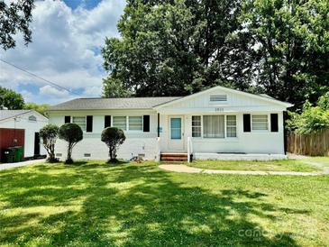 Charming white brick home with well-manicured lawn and symmetrical landscaping at 2823 Albany Ln, Charlotte, NC 28205