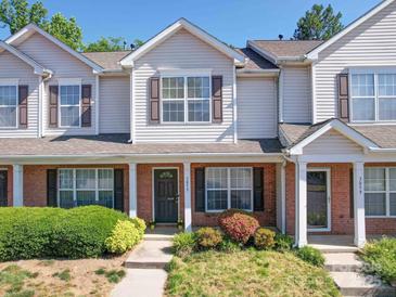Traditional townhome featuring a brick facade, neutral siding and well-maintained landscaping at 3055 Golden Dale Ln # 104, Charlotte, NC 28262