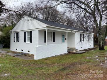 Charming white-brick ranch home featuring black shutters, covered porch, and a well-maintained front yard at 3701 Tipperary Pl, Charlotte, NC 28215