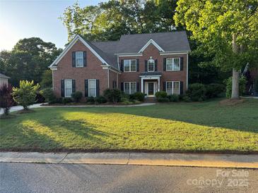 Traditional two-story brick home with a well-manicured lawn and mature trees at 4066 Belle Meade Cir, Belmont, NC 28012
