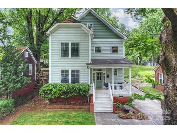 Charming two-story home with a covered front porch, manicured lawn, and lush landscaping adding to its curb appeal at 409 W Kingston Ave, Charlotte, NC 28203