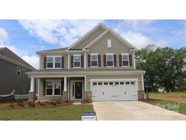 Two-story home featuring a two car garage, craftsman style columns, and a manicured front lawn at 9920 Emerson Glen Dr, Kannapolis, NC 28027
