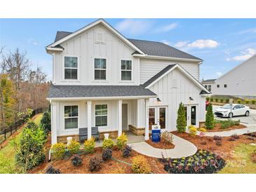 Charming new construction home boasts modern farmhouse design, inviting front porch, and professionally landscaped yard at 15008 Meadows Hunt Ln # 156, Huntersville, NC 28078