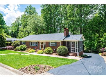 Charming brick home with lush landscaping, a screened porch, and a well-manicured front yard at 1602 Brentwood Dr, Newton, NC 28658