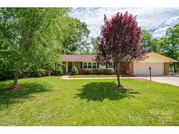 Charming brick ranch home with a well-maintained lawn, mature trees, and tidy landscaping at 227 Country Club Cir, Shelby, NC 28150