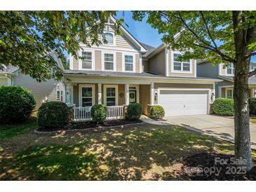 Charming two-story home featuring a well-maintained lawn, a covered front porch, and an attached two-car garage at 3664 Privette Rd, Matthews, NC 28104