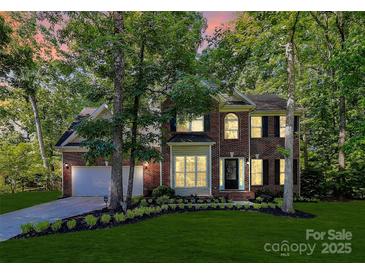 Charming brick two-story home with a well-manicured lawn and mature trees at 516 Aspen Ln, Indian Trail, NC 28079