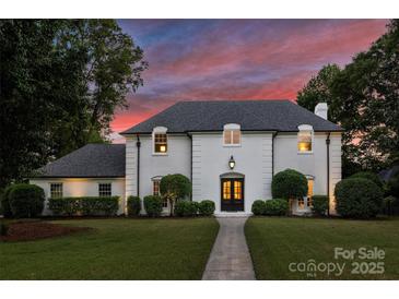 Stunning two-story white brick home with manicured lawn and beautiful trees at 5806 Bentway Dr, Charlotte, NC 28226