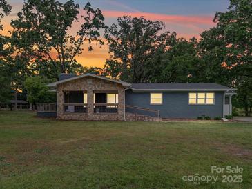 Charming single-story home features a stone porch, large yard, and beautiful sunset views at 6604 Plyler Mill Rd, Monroe, NC 28112