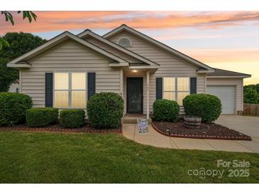 Charming single-story home featuring manicured landscaping and a welcoming front entrance at 908 Dairy Meadow Ct, Monroe, NC 28110