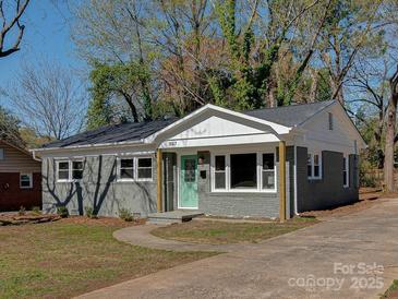 Charming gray brick home with a well-manicured lawn and a welcoming light-green front door at 1147 Norland Rd, Charlotte, NC 28205