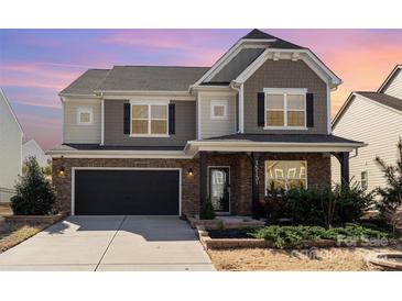 Charming two-story home with brick and siding exterior, landscaped front yard, and attached two-car garage at 15131 Oleander Dr, Charlotte, NC 28278