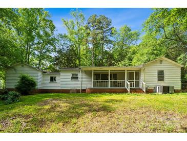 View of home's rear exterior showing the screened-in porch and ample backyard space at 1917 Tom Sadler Rd, Charlotte, NC 28214