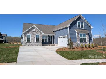 Charming, newly constructed blue home featuring stone accents, a paved driveway, and manicured front lawn at 1945 Hendricks St, Rock Hill, SC 29732