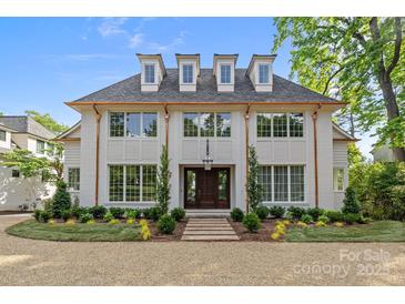 Stunning two-story home with white brick, gray roof, dormers, and beautifully landscaped front yard at 2710 Briarcliff Pl, Charlotte, NC 28207
