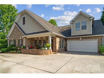 Charming brick home with a covered porch, two-car garage, mature trees, and a spacious driveway at 286 Liverpool Rd, Rock Hill, SC 29730