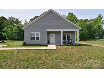 Charming single-story home with gray siding, a covered porch, and a well-manicured lawn at 325 Cornwall Dr, Salisbury, NC 28147