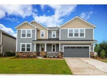 Two-story home with gray siding, stone accents, covered porch, and attached two-car garage at 1119 Bellshill Dv, Indian Trail, NC 28079
