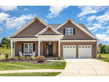 Charming home featuring a well manicured lawn, rocking chair front porch, and a two-car garage at 19031 Brandon James Dr, Cornelius, NC 28031