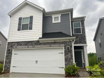Two-story home featuring gray and white siding, stone accents, and a two-car garage at 345 Hyssop Ct, Fort Mill, SC 29715