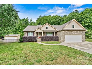Charming brick home with well-manicured lawn, mature trees, and inviting curb appeal at 7020 Cedar Ridge Ct, Mount Holly, NC 28120
