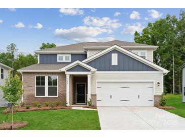 Charming two-story home featuring a brick facade, a two-car garage, and a well-manicured lawn at 9944 Manor Vista Trl, Kannapolis, NC 28027