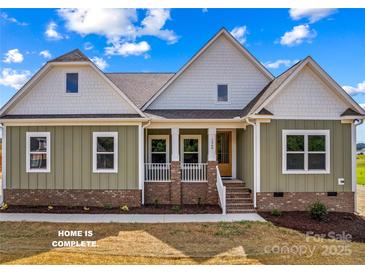 Charming home showcasing a welcoming front porch with brick accents and well-maintained landscaping at Lot 101 Coppergate Dr, Salisbury, NC 28147