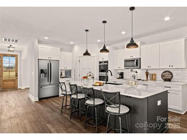 Bright kitchen features a large island with seating, stainless steel appliances, and white cabinetry at Lot 101 Coppergate Dr, Salisbury, NC 28147