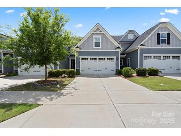 Charming townhome featuring a two-car garage, manicured lawn and tree offering curb appeal at 1108 Stella Ct, Monroe, NC 28110