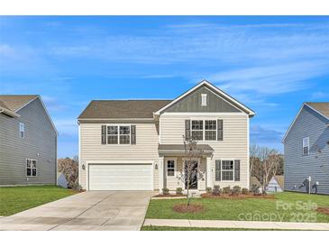 Charming two-story home boasts a manicured lawn, two-car garage, and classic architectural details at 1711 Wooten Way, Bessemer City, NC 28016