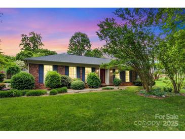 Charming one-story brick home with lush green lawn and landscaping, inviting curb appeal at 1940 12Th Ne St, Hickory, NC 28601